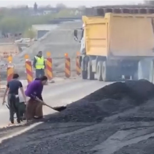 De ce lipsesc AUTOSTRĂZILE în România? Imagini video revoluționare! O femeie încarcă bitum în roabă cu o lopată.